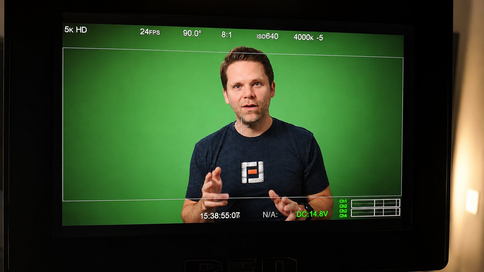 Presenter on green screen through the cinema camera monitor